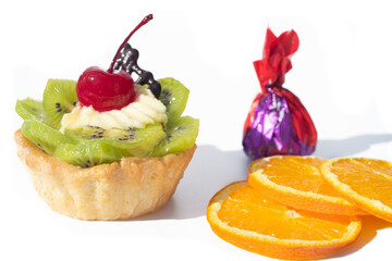 Cake with kiwi cherries and custard, near slices orange. White background,