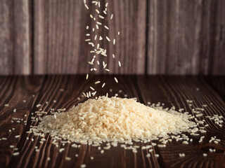 Granos de arroz cayendo en una mesa de madera.