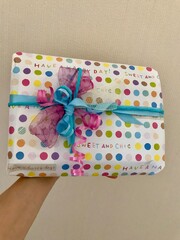 Closeup of a beautifully wrapped gift with handmade ribbon and colorful wrapping paper presented on the occasion of a birthday celebration