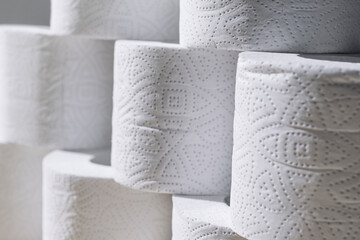 Rolls of toilet white paper stand on top of each other.