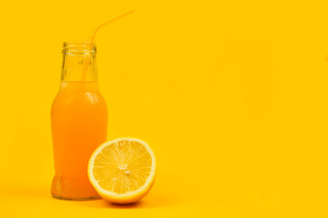 a bottle of aplexin juice with a small turbochka stands next to a lemon on a yellow background