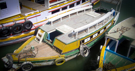 Fototapeta na wymiar Yellow and green boat at Ilha de Mare, Salvador, Brazil