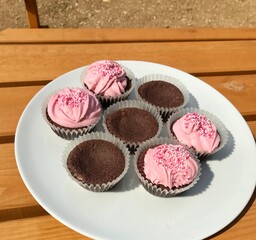 Closeup of sugary homemade chocolate cupcakes with lovely pink frosting and sprinkles to celebrate a birthday