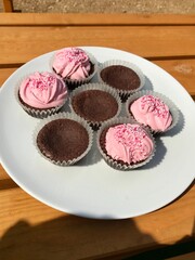 Closeup of sugary homemade chocolate cupcakes with lovely pink frosting and sprinkles to celebrate a birthday