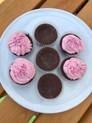 Closeup of sugary homemade chocolate cupcakes with lovely pink frosting and sprinkles to celebrate a birthday