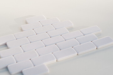 puzzle of white figures, brickwork