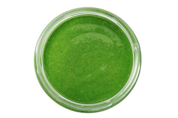 Pesto sauce in a glass bowl isolated on a white background, top view