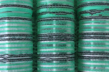 Close-up of pile of hair curlers. Green curlers.  Background texture of plastic hair curlers or rollers in green color  for styling hair, full frame overhead close up view
