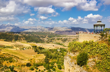 Fototapeta premium Ronda, Spain: Wide angle view of famous Ronda village situated solely on mountaintop against dramatic clouds