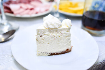 A piece of white cake on a white plate
