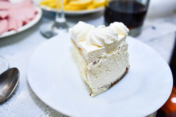 A piece of white cake on a white plate