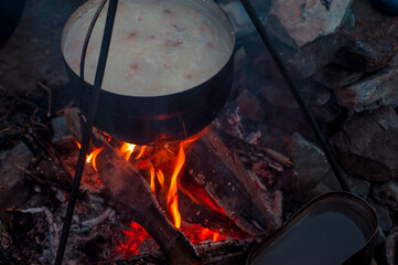 soup on a fire in a pot in hiking conditions, cooking on a fire