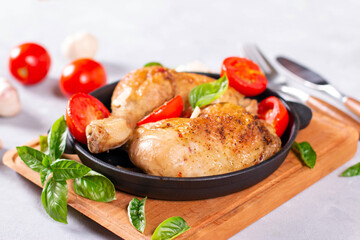 Hot food: fried quarters chicken legs with spices and basil, close-up on the table