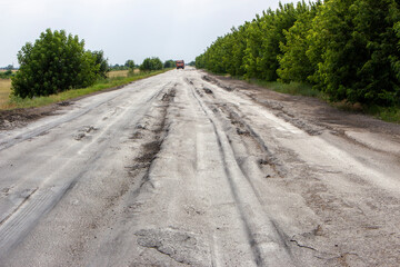 Damaged road by truck. Asphalt pits from heavy trucks. Congestion on the road.