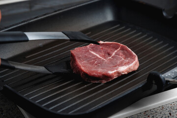 Raw aged Angus steak, fried in a cast-iron pan. Fluted frying pan.