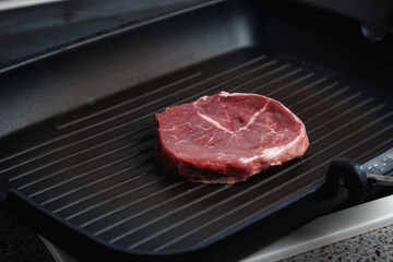 Raw aged Angus steak, fried in a cast-iron pan. Fluted frying pan.