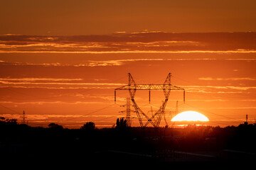 Electricity transmission line tower with sunset in the background