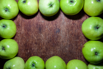 frame of green apples on old wooden background. free text space in the center. Eco style