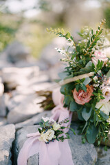 The groom's budier of white flowers against the background of a bouquet, stone and pink ribbon