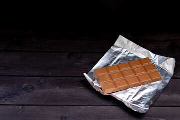 Bar of chocolate on wooden background