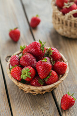 Healthy breakfast with ripe sweet berries. Fresh strawberries in basket on wooden table.