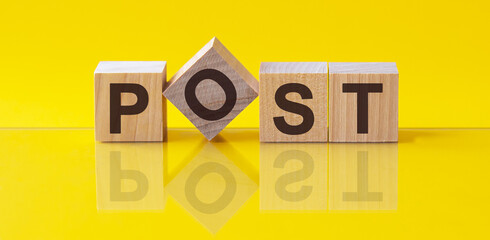word post on wooden cubes on yellow background