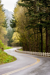 A winding section of the old Columbia River Highway near Multnomah Falls, Oregon.  Guard rail is the old wooden type.