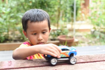 Boy playing cars on the table
