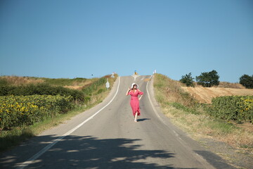 A beautiful romantic woman, in a pink dress and hat,