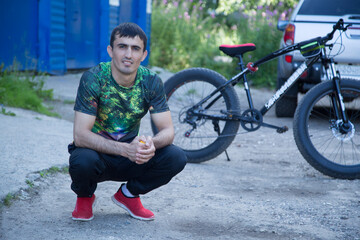 A young man with an electric bike on a city street.