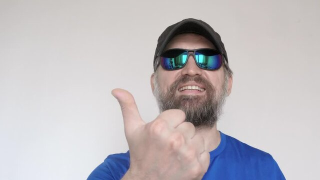 Mature man in sun glasses shows hands count with his fingers and smiles