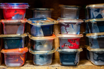 Clear containers of different colr printer's ink on a shelf