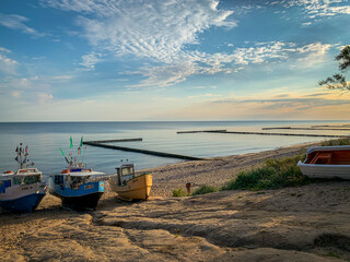Obraz premium At Beach of Jaroslawiec in Poland fishing boats lie on the beach of the Baltic Sea