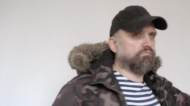 Man in sailor's vest puts on warm coat and zips it