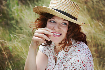 portrait beauté d'une jeune et jolie femme rousse souriante dans un prairie en été au soleil avec des herbes sauvages 