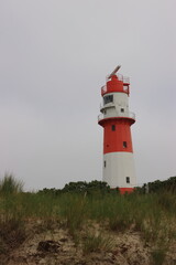 Fototapeta na wymiar Roter Leuchtturm an der Küste 