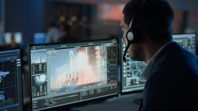 Flight Director Counts Down the Seconds Before Space Rocket Launch. Team in Mission Control Witness Successful Lift Off. Flight Control Employees Sit in Front of Computers and Monitor the Mission.