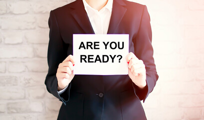 woman showing white card with ARE YOU READY? word . Business concept