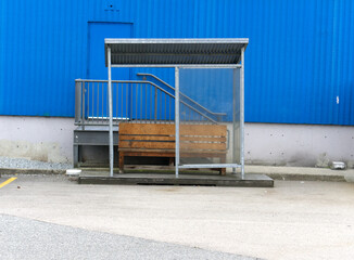 urban landscape bench in shelter against blue industrial wall