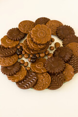 Milky and bitter round shape chocolate Madlen,designed on glass plate,at black background with copy space.Top view