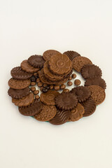 Milky and bitter round shape chocolate Madlen,designed on glass plate,at black background with copy space.Top view.