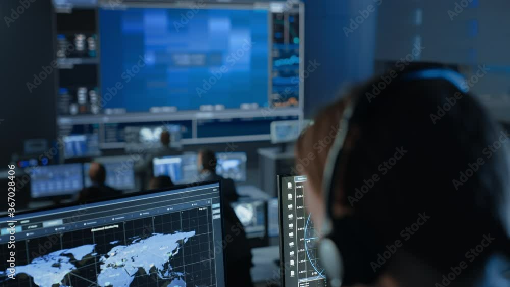 Aufkleber Computer Screen with Global Map Technology Used by a Female Flight Controller in a Mission Control Center Room with Other Scientists. Team of Engineers Work in Monitoring Room Full of Displays.
