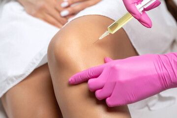 Doctor doing stem cell therapy on a patient's knee after the injury. Treating knee pain with...