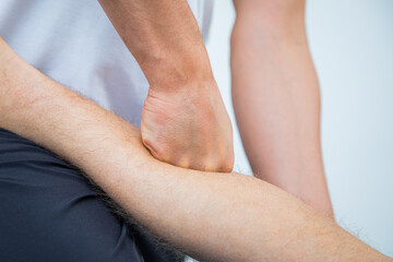 Physical therapist for adult men performs a therapeutic stretching