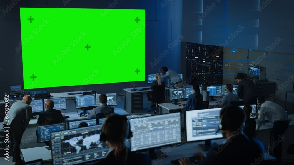 Poster Big Green Screen Horizontal Mock Up in a Control Center Room with Engineers and Controllers Working on Computers. Team of Telecommunication Employees Work in Monitoring Room Full of Displays.
