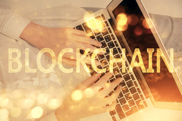 Double exposure of woman hands working on computer and blockchain theme hologram drawing. Top View....