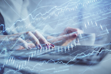 Multi exposure of woman hands typing on computer and financial graph hologram drawing. Stock market analysis concept.