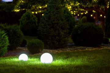 backyard ground light garden with lantern electric lamp with sphere diffuser in green grass and...