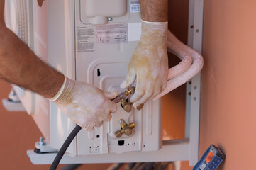 Hands of a gentleman working to connect a gas hose