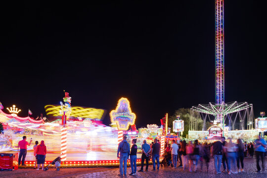 Night atmosphere with spinning and illuminating  amusement ride, "Octopus or Breakdance, and Chain carousel, with long exposure at Rheinkirmes in D&uuml;sseldorf, Germany.